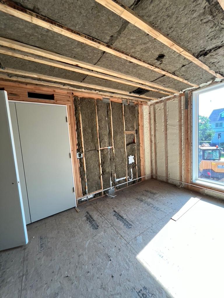 Before spray foam insulation - exposed studs and fiberglass